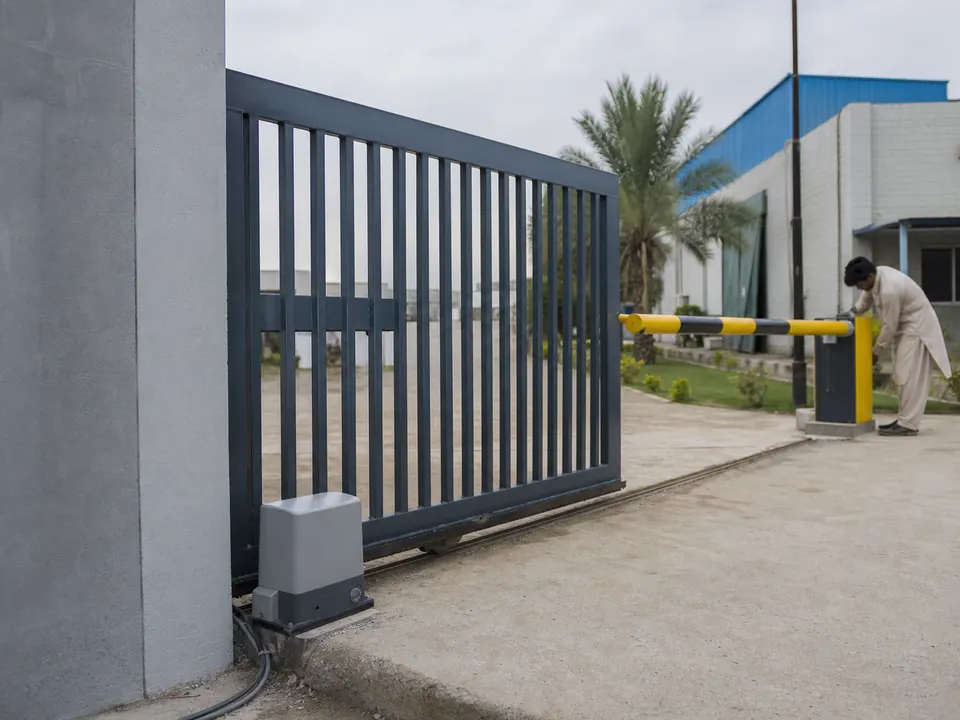 Motorised sliding gate at a compound entrance with the drive unit at its base